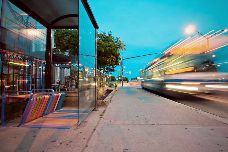 Sidewalk and a bus driving by